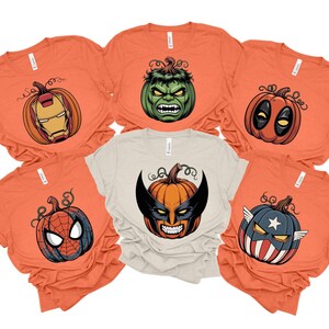 a collection of orange t-shirts with various Halloween-themed designs, including a Hulk, a Deadpool, Spider-Man, and an American flag.