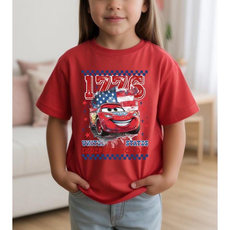 A young girl wearing a red t-shirt with a graphic of a red car and an American flag, along with the text "1776 United States".
