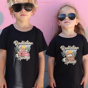 two little girls wearing sunglasses standing next to a pink wall