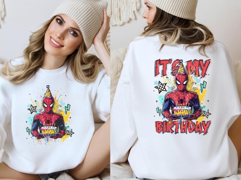 A woman wearing a white sweater with a Spiderman graphic and the text "It's my birthday" printed on the back.