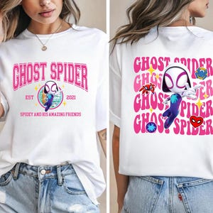 a woman wearing a white t-shirt with a graphic design of a character from the Spider-Man franchise.