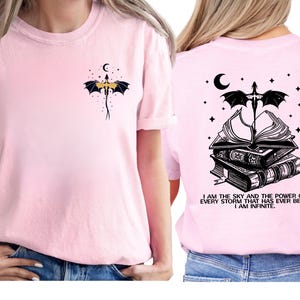 A woman wearing a pink t-shirt with a dragon and a quote printed on the back.