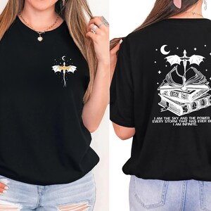 A woman wearing a black t-shirt with a graphic design on the front and back.