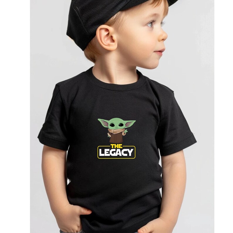 a young child wearing a black shirt and a black hat