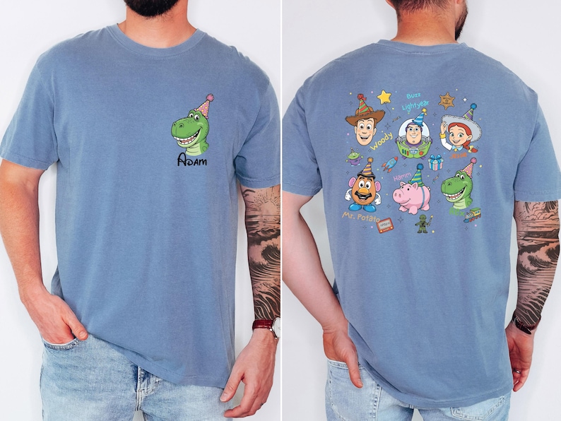 Puede incluir: Camiseta azul con un dinosaurio de dibujos animados con un gorro de fiesta y el nombre "Adam". La parte trasera de la camiseta muestra personajes de Toy Story con gorros de fiesta, como Woody, Buzz Lightyear y Jessie.