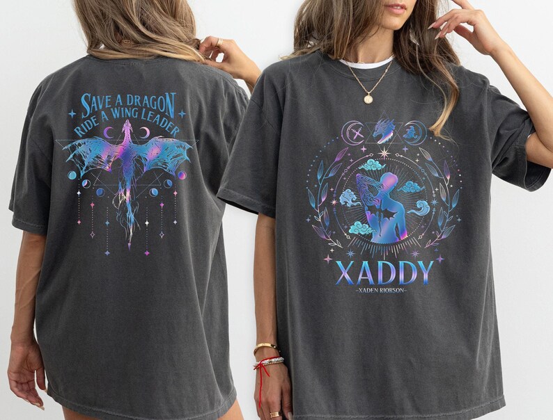 May include: A black oversized t-shirt with a graphic print of a dragon and the text "Save a Dragon Ride a Wing Leader". The back of the shirt has a graphic print of a person with a dragon and the text "XADDY - XADEN ROBINSON -"