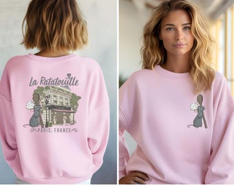 May include: Pink sweatshirt with a graphic of Remy the rat from the movie Ratatouille. The graphic includes the text "La Ratatouille" and "Paris, France".