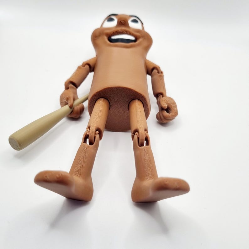 Puede incluir: Una figura articulada marr&oacute;n con una cara sonriente que sostiene un bate de b&eacute;isbol de madera. La figura tiene brazos y piernas articulados.