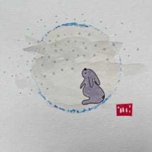 Puede incluir: Pintura a la acuarela de un conejo morado mirando hacia arriba a un círculo gris con detalles azules, posiblemente representando la luna. La obra de arte está sobre papel blanco con un sello cuadrado rojo.