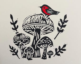 May include: Black and white linocut print of mushrooms with a red bird perched on top of the largest mushroom.