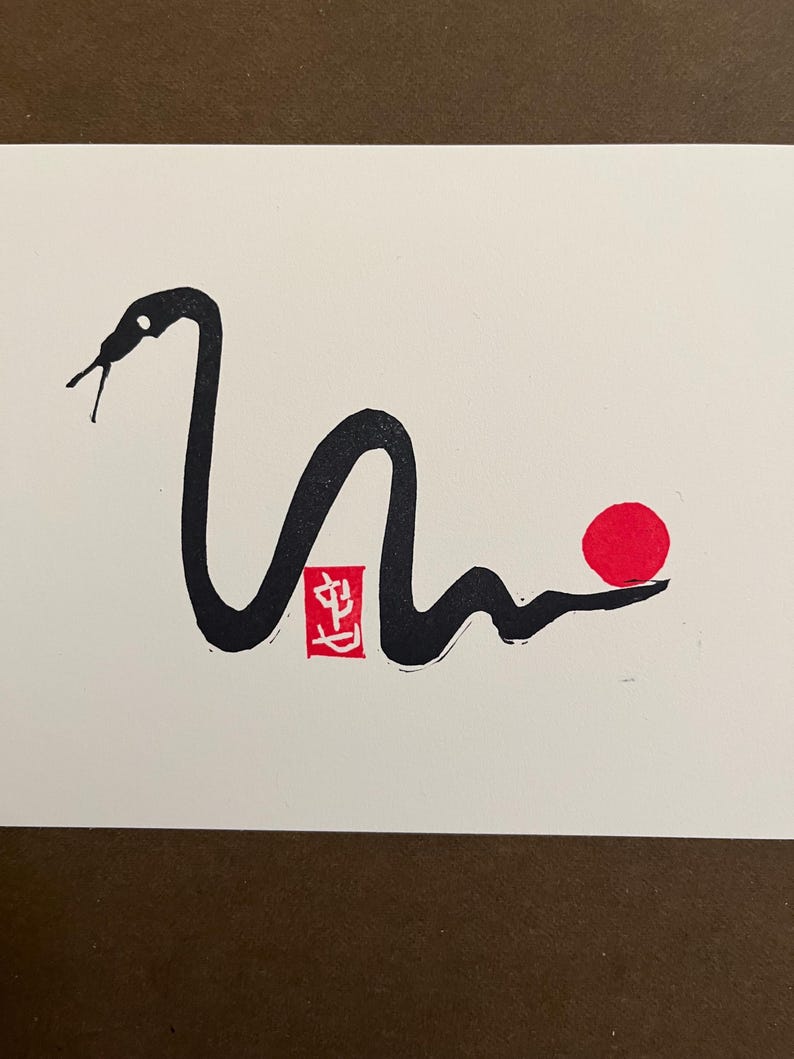 Peut inclure: Dessin &agrave; l'encre noire et blanche d'un serpent avec un cercle rouge et un tampon rouge avec le caract&egrave;re chinois "生" (prononc&eacute; shēng, signifiant "vie") sur un fond blanc.