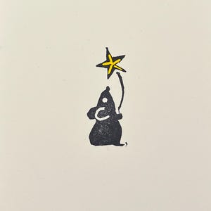 May include: A black silhouette of a small creature holding a yellow star above its head.