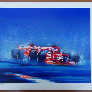 Peut inclure: Une impression vibrante d'une voiture de course de Formule 1 rouge traversant l'eau, créant un effet d'éclaboussure. La voiture est placée sur un fond bleu avec des accents blancs, suggérant la vitesse et le mouvement. L'œuvre est sur fond blanc.