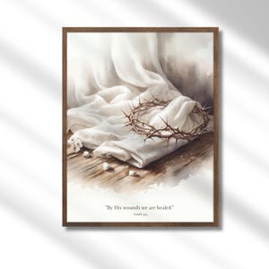 Puede incluir: Una pintura de acuarela de una corona de espinas descansando sobre un paño blanco. El paño está drapeado sobre una superficie de madera. La pintura tiene una cita de Isaías 53:5, "Por sus heridas somos sanados."