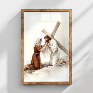 May include: Watercolor painting in a wooden frame depicts a religious scene. A figure in white kneels, wearing a crown of thorns, with a cross behind them. Another figure in brown kneels, touching the first figure's face. The artwork is set against a soft, light background.