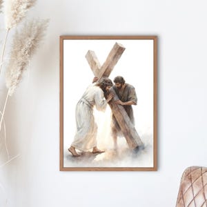 May include: Framed watercolour print showing two figures bearing a large wooden cross. One figure wears a crown of thorns and a white robe, the other a brown robe. The artwork has a soft, ethereal quality.