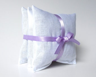 May include: Two white linen pillow sachets tied together with a lavender ribbon.