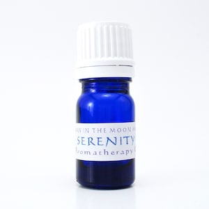 May include: A small blue glass bottle with a white cap. The bottle has a white label with the text "SERENITY Aromatherapy" on it.