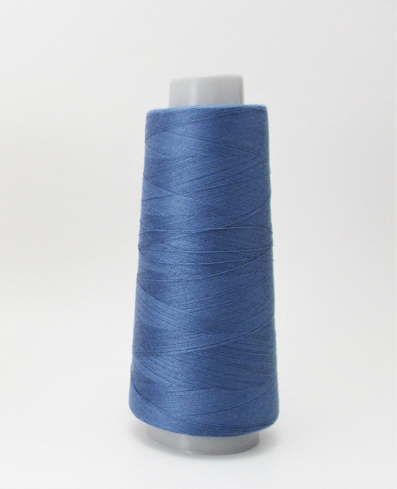 May include: A spool of blue thread on a white background.