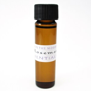 May include: A small amber glass bottle with a black cap, labeled "In the Moon Rosemary Essential".