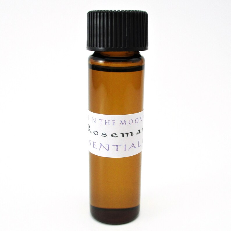 May include: A small amber glass bottle with a black cap, labeled "In the Moon Rosemary Essential".