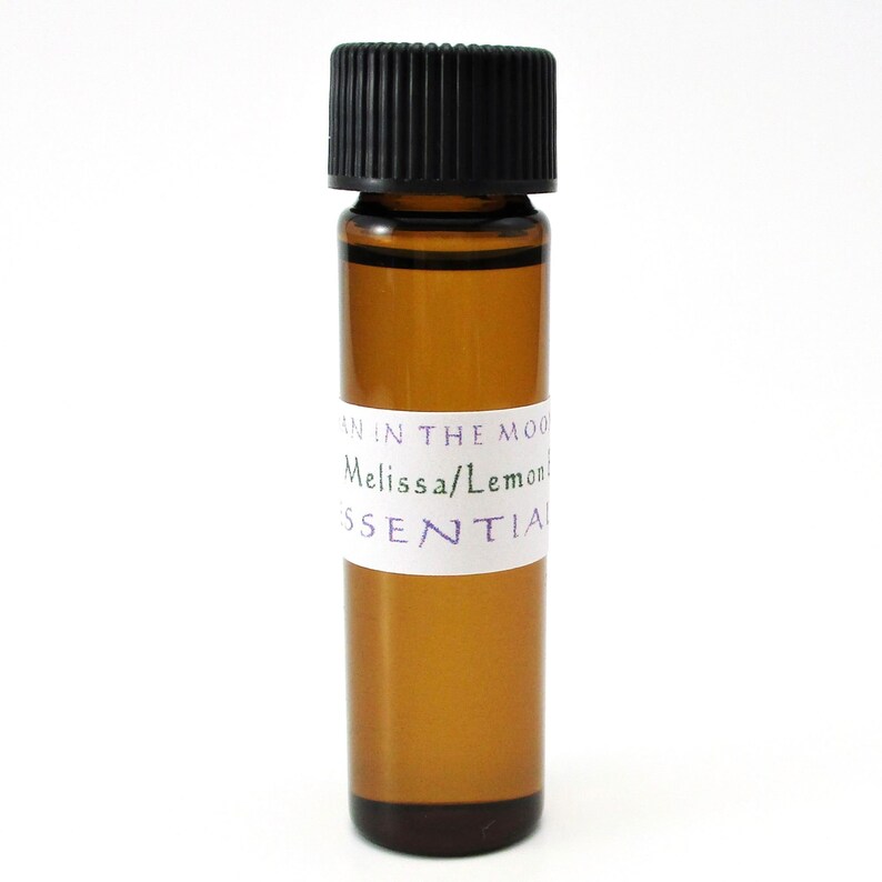 May include: A small amber glass bottle with a black cap, labeled "Moon in the Mood Melissa/Lemon Essential".
