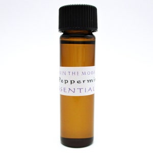 May include: A small amber glass bottle with a black lid. The bottle is labeled "Peppermint Essential Oil" with a white label and purple text.