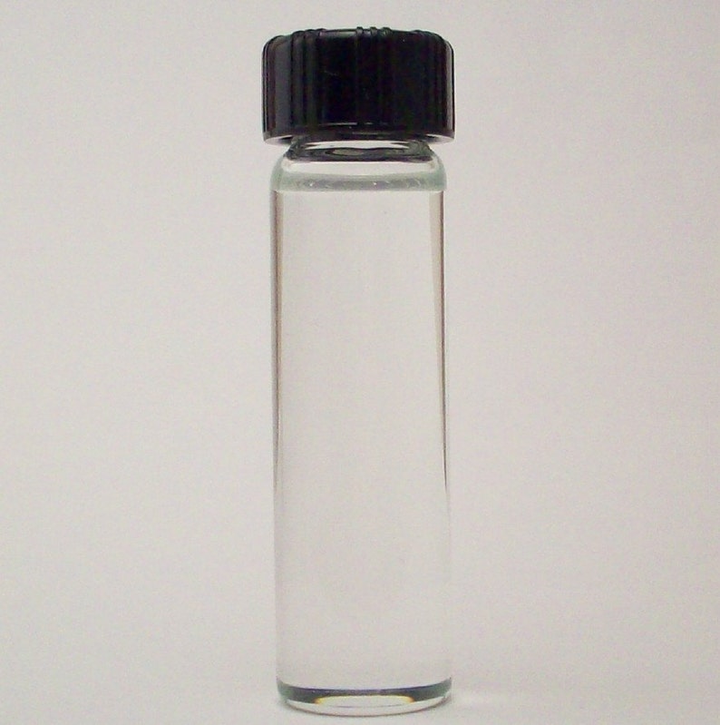 May include: A clear glass bottle with a black screw-on cap. The bottle is filled with a clear liquid.