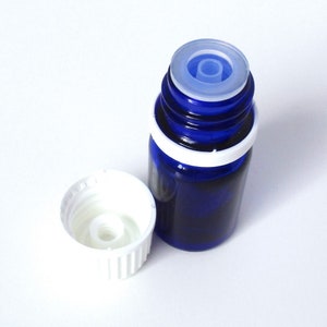 May include: A blue glass bottle with a white cap and a clear dropper. The bottle is partially filled with a dark liquid.