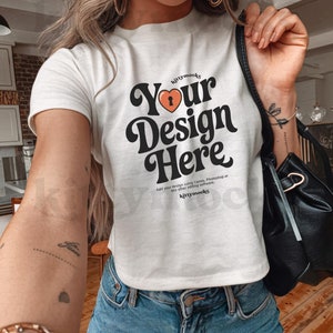 May include: White t-shirt with a retro-style graphic that says "Your Design Here" with a heart and keyhole design. The text "kittymocks" appears above and below the graphic.