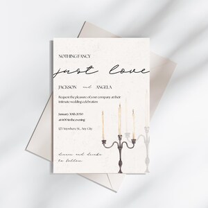 May include: Wedding invitation with a simple design featuring the text "NOTHING FANCY just love" and the names "JACKSON and ANGELA". The invitation includes the date and time of the wedding, the address, and the text "dinner and drinks to follow". The invitation is decorated with a watercolor illustration of a candelabra with lit candles.