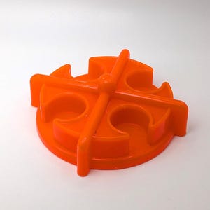 May include: Orange plastic toy carousel with four seats. The carousel is designed to spin around and has a central hub.