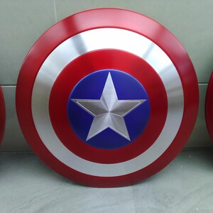 May include: Two red, white, and blue Captain America shields. The shields are round and have a five-pointed star in the center.