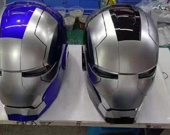 May include: Two metallic silver and blue Iron Man-style helmets. One helmet is primarily silver with blue accents, and the other is silver with black accents. The helmets have a sleek, futuristic design.