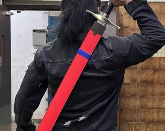May include: A person wearing a black jacket and jeans is holding a red and blue sword scabbard over their shoulder. The scabbard has a black leather strap and a silver metal tip. The person is standing in a hallway with a sign that reads "Block A - 2/F A,B,C ← D,E,F,N".