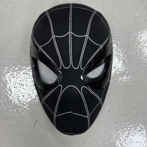 Op de afbeelding: Zwart Spider-Man-masker met een wit spinnenwebontwerp en een zwarte gaasoogbedekking.
