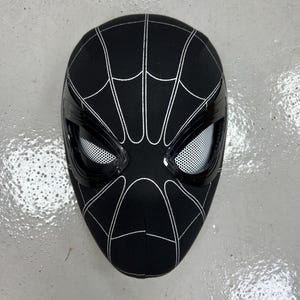 Op de afbeelding: Zwart-witte Spider-Man-masker met een gaasoogbedekking. Het masker is gemaakt van stof en heeft een 3D-ontwerp.