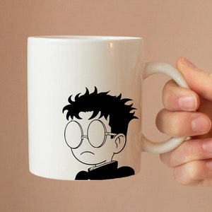 May include: White ceramic mug featuring a black and white illustration of a person wearing glasses. The person has short, dark hair and is wearing a collared shirt.