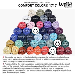 May include: A display of rolled Comfort Colors 1717 unisex dyed t-shirts in various colors, including white, black, and blue. The image includes text indicating the brand and garment type, with a note about color variations.