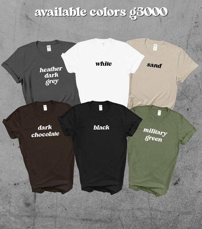 May include: A collection of six t-shirts in various colors: heather dark grey, white, sand, dark chocolate, black, and military green. Each shirt displays its color name in a simple, white font.