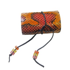 May include: A small, orange and red snakeskin pouch with a black drawstring and colorful beads. The pouch is tied closed with the drawstring.