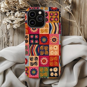 May include: A rectangular smartphone case featuring a vibrant, multi-colored patchwork design. The surface is covered in a grid of squares displaying various floral motifs, wavy lines, and geometric patterns in shades of red, blue, yellow, and pink.