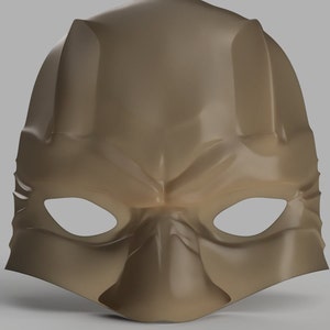 May include: A brown plastic mask with two eye holes and a pointed chin. The mask has a textured surface and a slightly menacing expression.