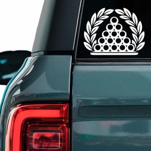 Könnte beinhalten: Weißer Vinyl-Autoaufkleber mit einem Billardkugel-Rack, umrahmt von einem Lorbeerkranz. Der Aufkleber befindet sich auf der Heckscheibe eines teal-farbenen SUV.