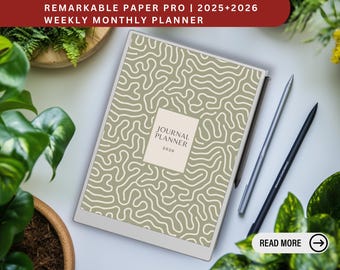 May include: A white e-reader with a gray and white abstract pattern on the screen. The screen displays the text "Journal Planner 2026". The e-reader is on a white surface with two black styluses and a green plant.