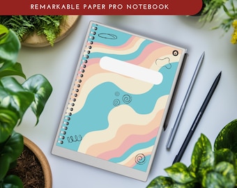 Può includere: Un taccuino digitale bianco e grigio con un design astratto colorato sulla copertina. Il design presenta linee ondulate in tonalità di rosa, giallo e blu. Il taccuino ha una rilegatura a spirale ed è appoggiato su una superficie bianca. Il testo "REMARKABLE PAPER PRO NOTEBOOK" è stampato in rosso nella parte superiore dell'immagine.