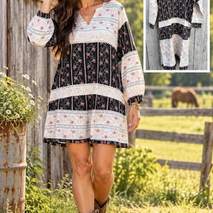 May include: A long-sleeve mini dress featuring a V-neckline and a patchwork design of black and white fabric panels. The dress displays alternating floral patterns, vertical stripes, and horizontal lace-like trim details throughout the garment.