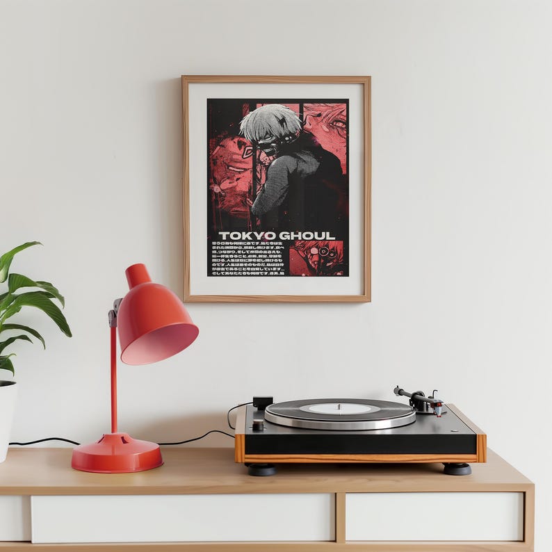 May include: A framed poster with a black and white illustration of a character from the anime Tokyo Ghoul. The character is wearing a black jacket and has red eyes. The poster has a red background with the text "TOKYO GHOUL" in white.