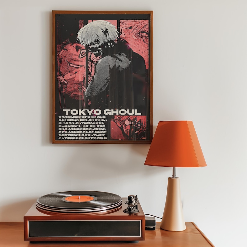 May include: A framed poster with a black and white illustration of a character from the anime Tokyo Ghoul. The poster has a red and black color scheme and the text "TOKYO GHOUL" is printed in white letters. The poster is hanging on a white wall above a record player and a lamp.