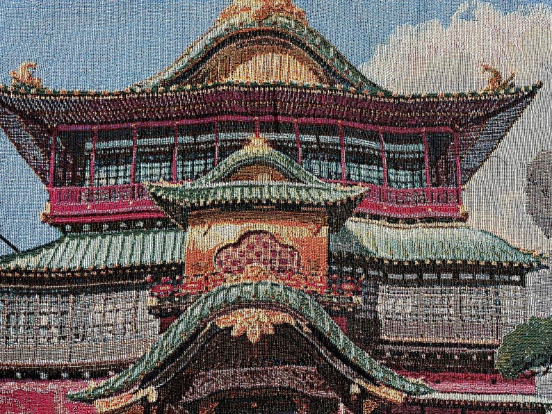 May include: A tapestry depicting a multi-tiered, ornate, red and gold pagoda with green tiled roofs. The pagoda is set against a blue sky with white clouds.